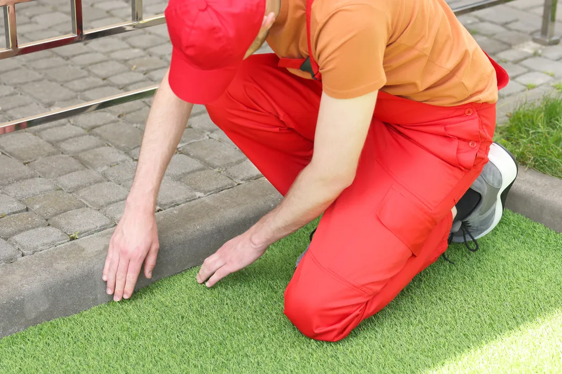 Installer trimming artificial turf to a clean edge during installation